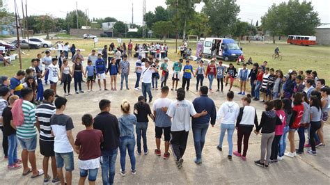 Foto de niños, jóvenes y adultos de diversas edades participando en actividades deportivas comunitarias al aire libre en un barrio