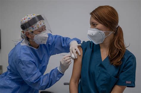 Personal de salud recibiendo una vacuna