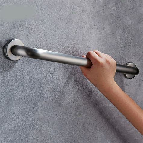 Persona mayor usando barra de apoyo en el baño