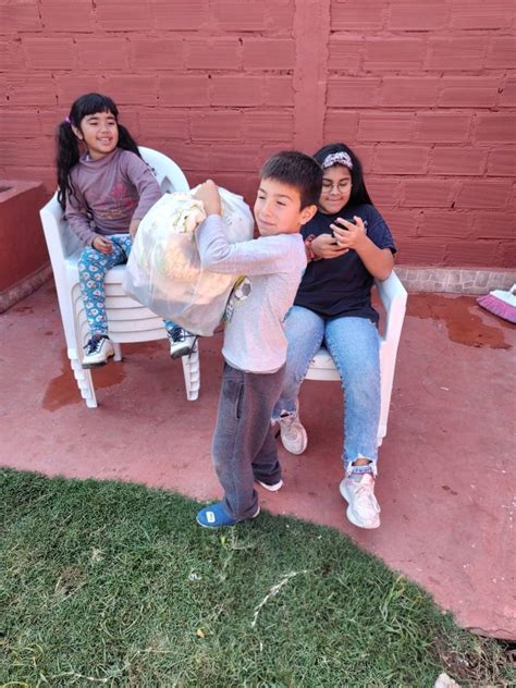Fotografía de niños recibiendo ropa donada con sonrisas