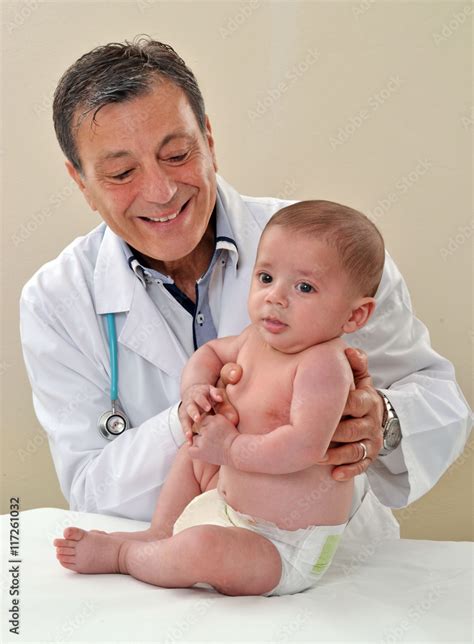Fotografía de un pediatra examinando a un bebé en un entorno familiar.