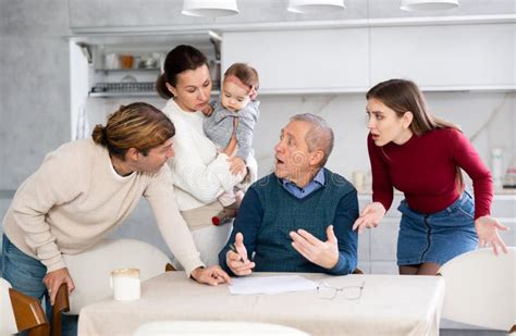Foto de una familia discutiendo la elección de una residencia para un adulto mayor en un ambiente cálido