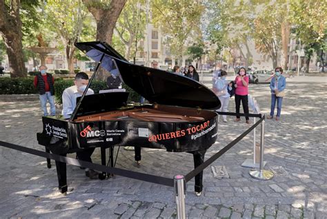 Orquesta juvenil tocando en un escenario al aire libre en un barrio