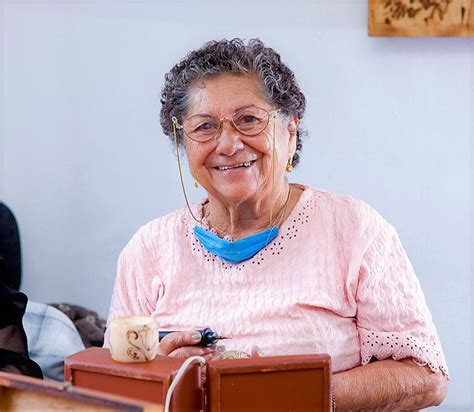 Mujer adulta mayor sonriente registrándose para un certamen de reina en una oficina municipal