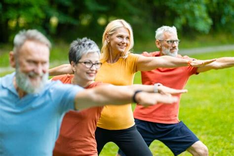 Foto de grupo de adultos mayores practicando yoga al aire libre