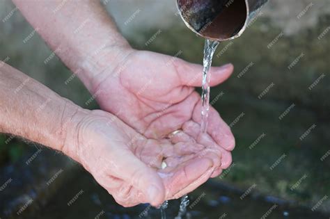 Persona con las manos recogiendo agua