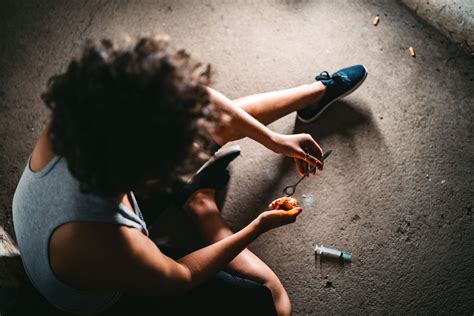 Foto de jóvenes consumiendo drogas en un espacio público deteriorado