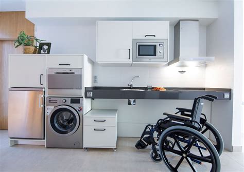 Cocina adaptada con encimeras de altura ajustable y electrodomésticos accesibles
