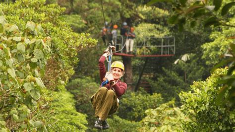 Foto de una persona mayor disfrutando de la tirolesa con un paisaje de selva tropical de fondo