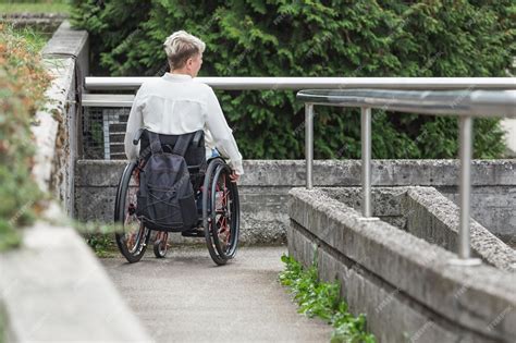 Fotografía de una persona con discapacidad física en silla de ruedas, superando una barrera arquitectónica