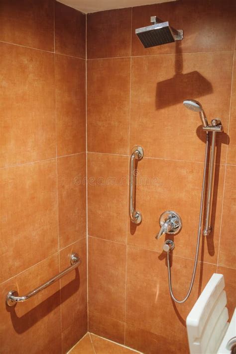 Foto de una ducha adaptada con asiento y barras de apoyo