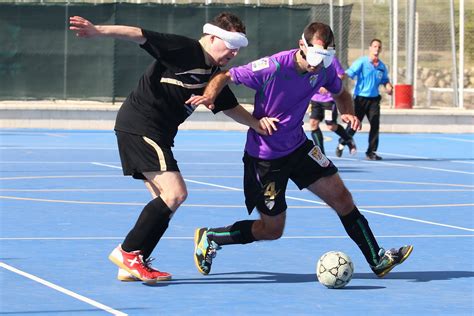 Atletas invidentes jugando al fútbol para ciegos en una cancha