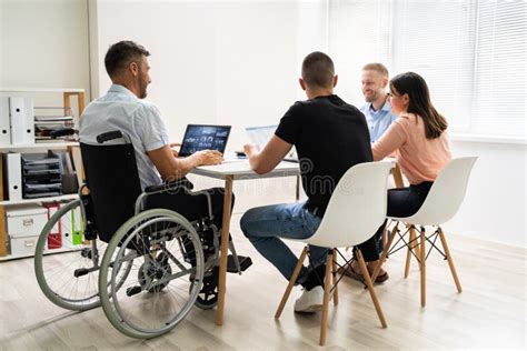 Persona con discapacidad utilizando una computadora en un entorno de oficina inclusivo