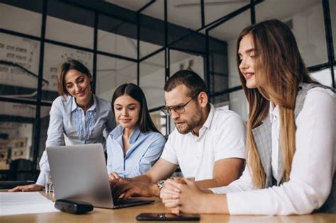 Grupo de personas diversas trabajando colaborativamente en una oficina, incluyendo personas con discapacidad
