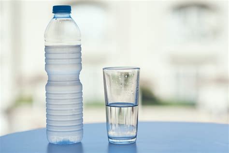 Imagen de un adulto mayor bebiendo agua y vasos de agua en la mesa