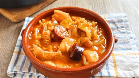 Plato de callos a la madrileña con una copa de vino tinto