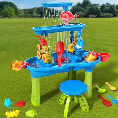 Mesa de arena y agua con personas mayores interactuando, utilizando herramientas y moldes para la estimulación sensorial.