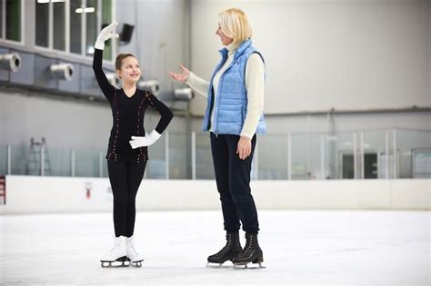 Entrenador de patinaje artístico dando instrucciones a un joven patinador