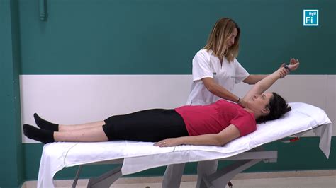 Profesional de la salud realizando movilización pasiva a un paciente en cama