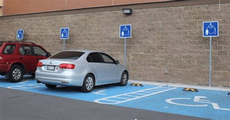 Fotografía de un vehículo estacionado correctamente en un espacio reservado para personas con discapacidad, mostrando el símbolo universal de acceso y un 