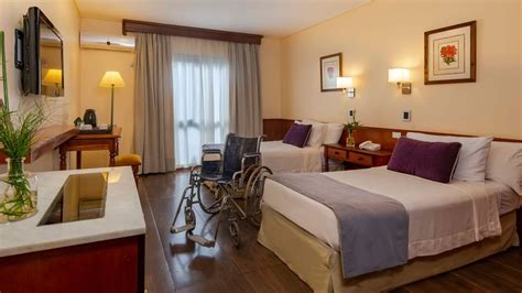 Dormitorio adaptado para adulto mayor con cama articulada y espacio para silla de ruedas