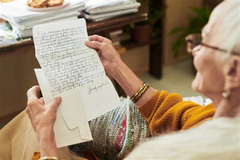 Abuela sonriendo y leyendo una carta escrita a mano.