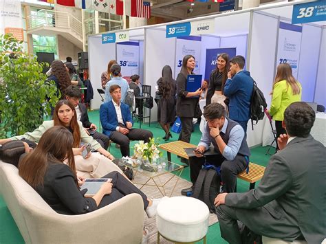 Fotografía panorámica de una feria laboral con stands y personas interactuando