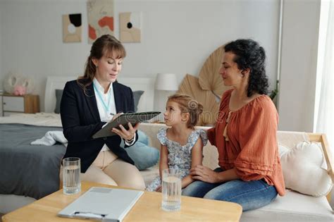 Representación de una familia interactuando con un trabajador social en su hogar, mostrando un ambiente de confianza.