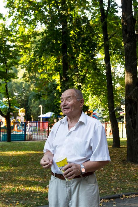 Foto temática de un jubilado en un parque consultando su móvil