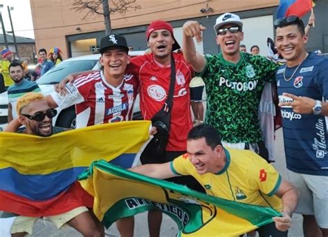 Foto de hinchas de fútbol con camisetas de sus equipos participando en la protesta