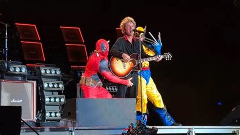 Los miembros de Green Day tocando violines mientras la barcaza se hunde