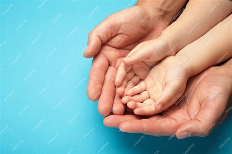 Foto de una mano adulta sosteniendo la mano pequeña de un niño, simbolizando apoyo y protección.