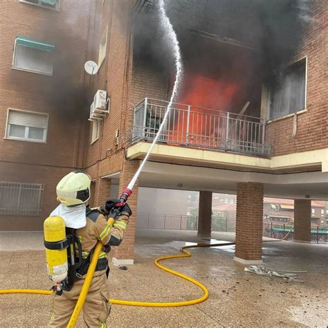 Fotografía de bomberos controlando un incendio en una residencia nocturna