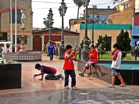 Foto temática de niños jugando en una plaza con una silueta de hogar de menores al fondo