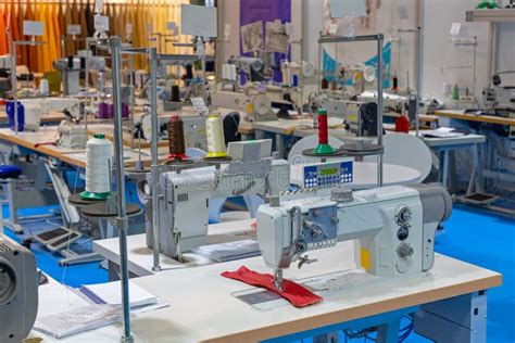 Mujeres aprendiendo a coser en un taller, con máquinas de coser y telas, mostrando concentración y creatividad.