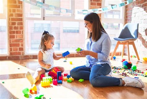 Foto de una niñera interactuando de forma empática y divertida con los niños
