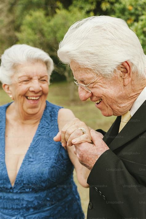 Foto de una pareja mayor sonriendo y tomándose de la mano, simbolizando intimidad y conexión.