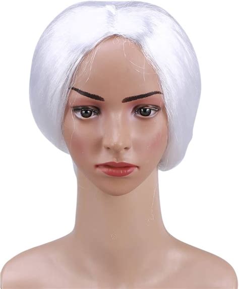 Persona con peluca de anciana blanca y gafas, sonriendo, como parte de una caracterización