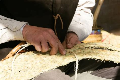 fotografía de una mujer Pehuenche trabajando en artesanía tradicional