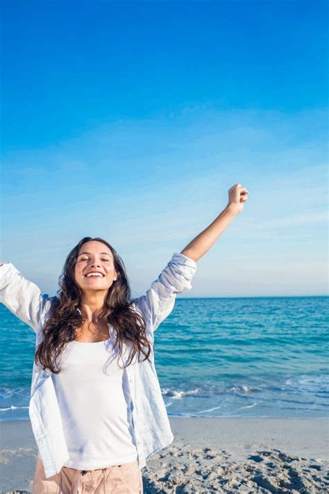 Mujer mayor sonriendo y posando con confianza en bikini en una playa
