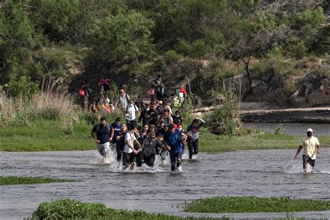 Fotografía de migrantes cruzando el río Bravo