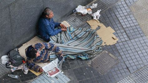 Foto de voluntarios entregando ayuda a personas en situación de calle en un contexto urbano