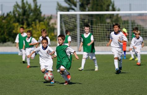 Imagen de una cancha de fútbol juvenil con niños jugando