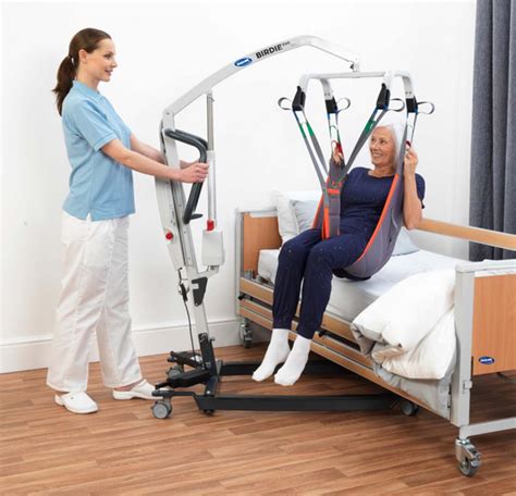 Esquema o foto de una grúa de traslado para pacientes, destacando su sistema de elevación y ruedas.