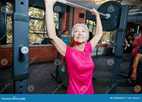 Anciana levantando pesas en el gimnasio.