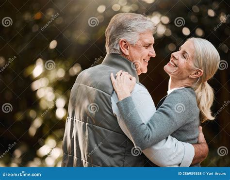 Foto de una pareja de adultos mayores sonriendo y disfrutando de una cita al aire libre
