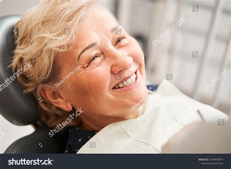 Persona jubilada sonriendo en consulta dental
