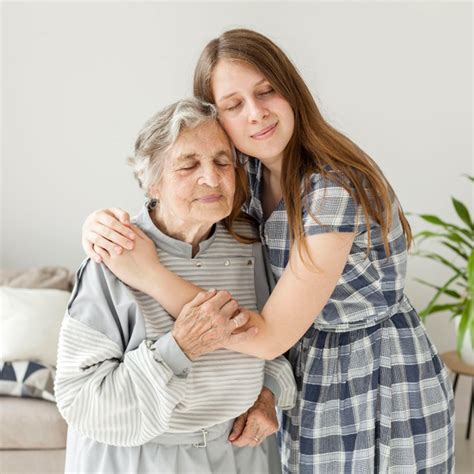 Foto de una nieta o nieto conversando animadamente con su abuela, quizás revisando un álbum de fotos