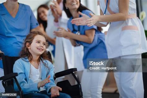 Ilustración o foto de personal sanitario aplaudiendo a un paciente que es dado de alta de un hospital.