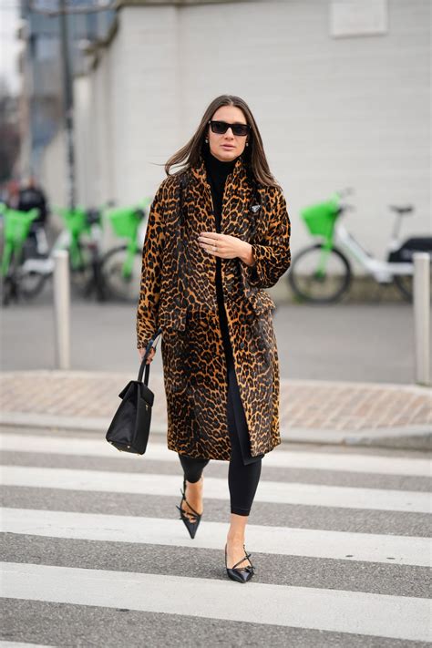 Mujer senior con un total look negro y detalles de estampado de leopardo, mostrando confianza